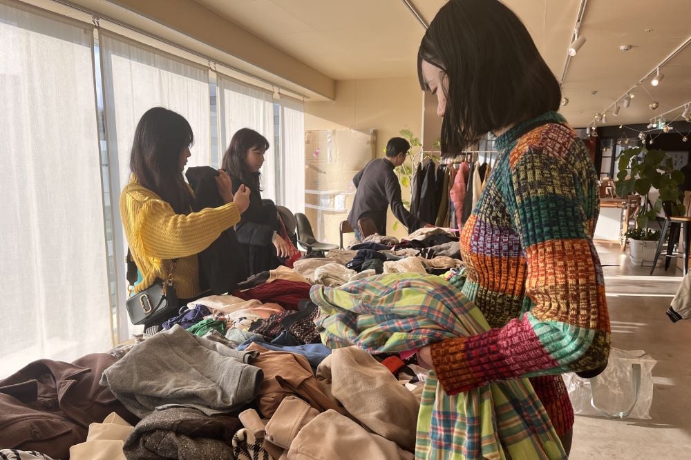 長机の上に大量の洋服が並んでいる様子